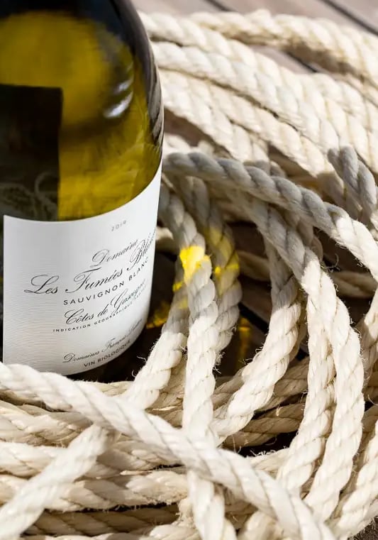 une bouteille de vin blanc avec des cordes de bateau