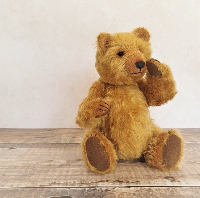 a handmade teddy bear sitting on a table