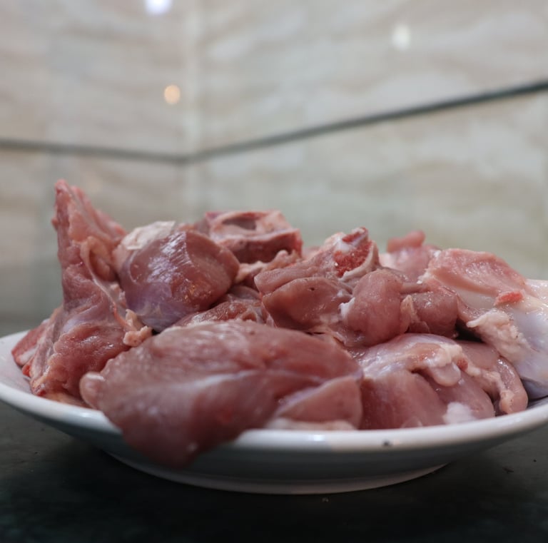a bowl of raw meat curry cut on a counter top