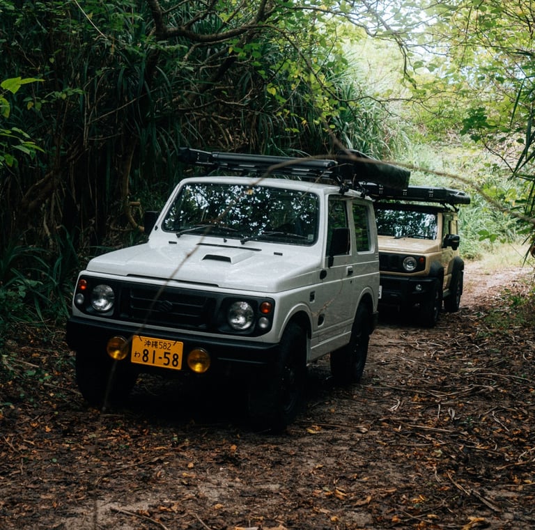 Two off-road Suzuki Jimny camping cars driving through a lush forest trail in Okinawa. | Evertrail Okinawa