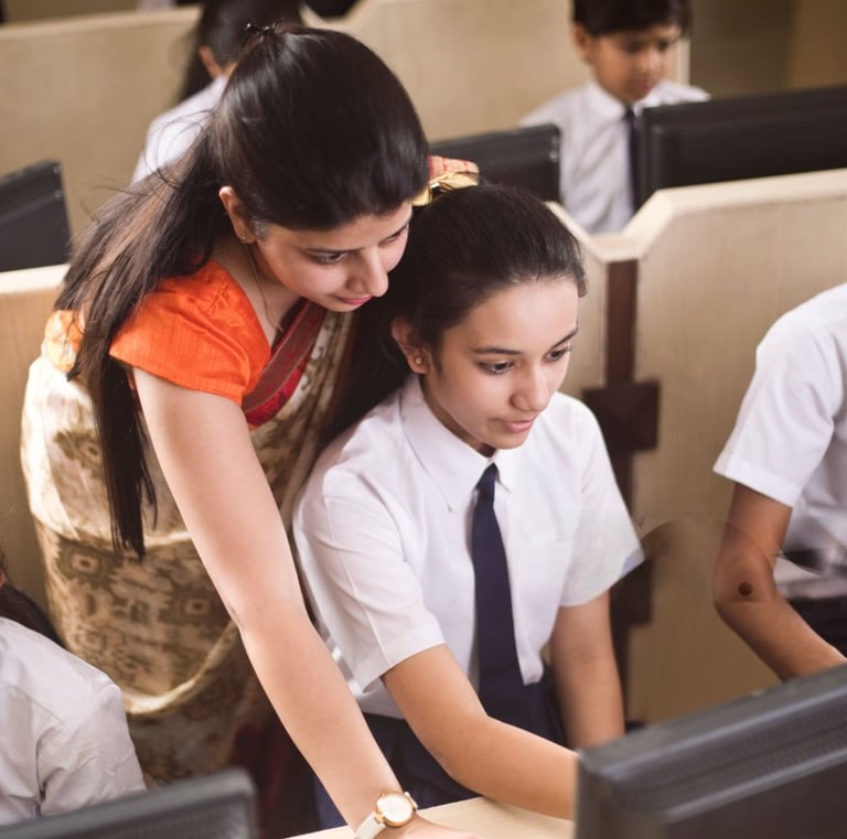 Student learning digital skill at Smart Village Computer Hub. Instructor teaching. 