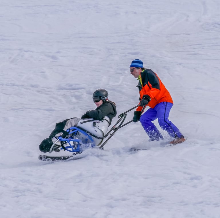 Sauveteur qui descend une skieuse blessée