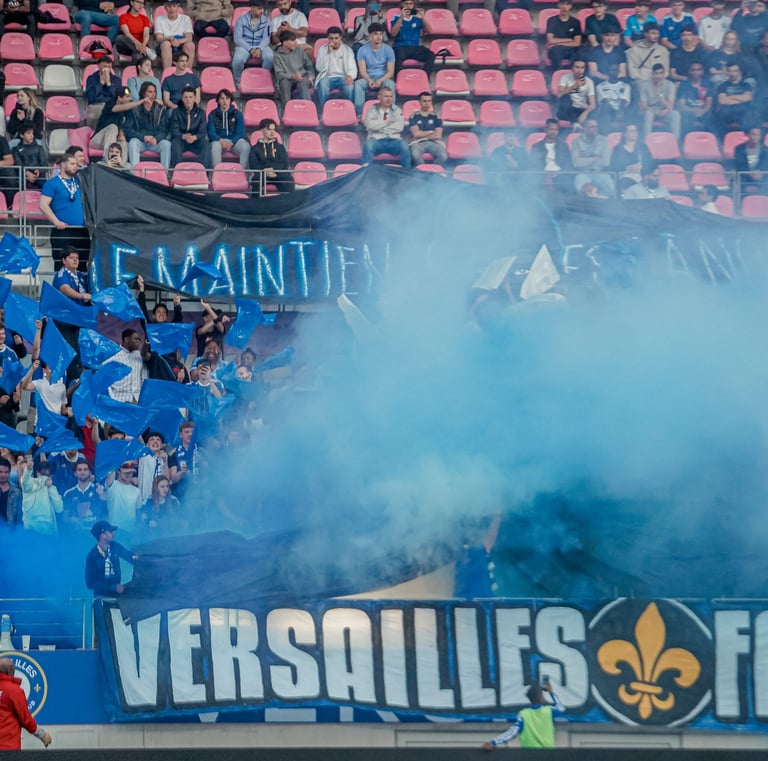 Groupe de supporters de Versailles qui craquent des fumigènes