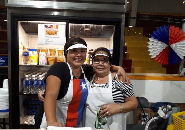 two women standing in front of a counter top