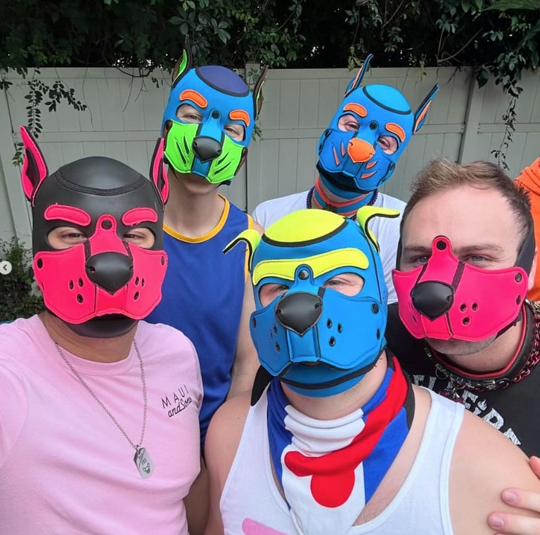 Five men posing in colorful pup masks.