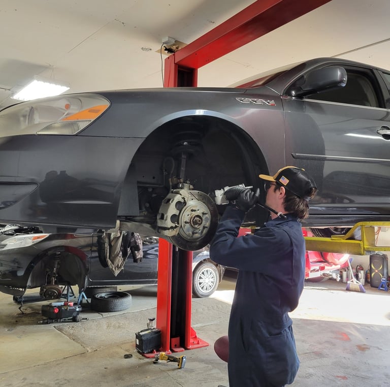 Mechanic Hard at Work Fixing Brakes and Suspension