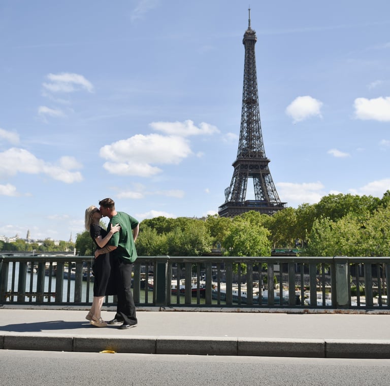 Deux amoureux s'embrassent sur le pont bir hakeim avec la tour eiffel en fond, il fait beau