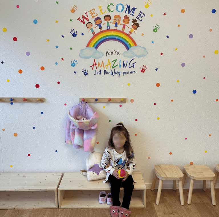 Willkommensbereich für Kinder mit Regenbogen-Dekoration – positive Atmosphäre in der Spielgruppe Spr