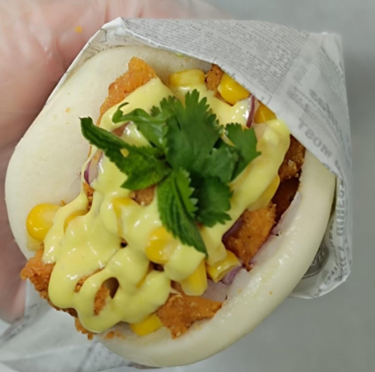 a person holding a sandwich with cheese and cheese