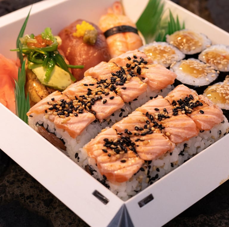 a box of sushi with salmon and vegetables