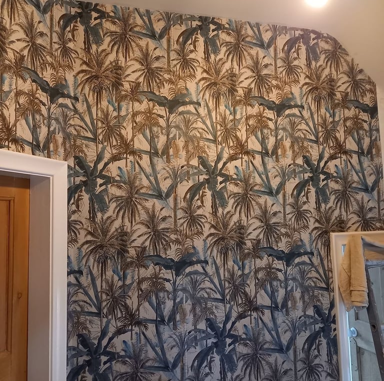 a bathroom with a wallpapered wall showing palm trees