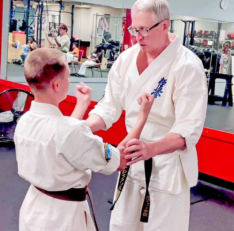 Shihan David Pickthall adjusting a brown belt student during Sanchin kata at Kyokushin Karate USA Rochester NY