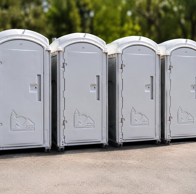 Fila de baños portátiles blancos numerados, listos para instalación en Venezuela