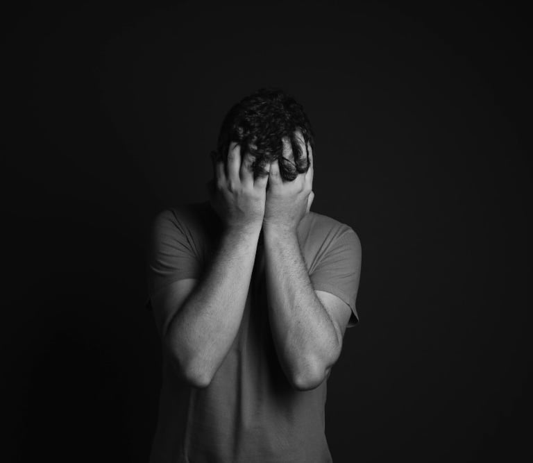 a man holding his hands up to his face