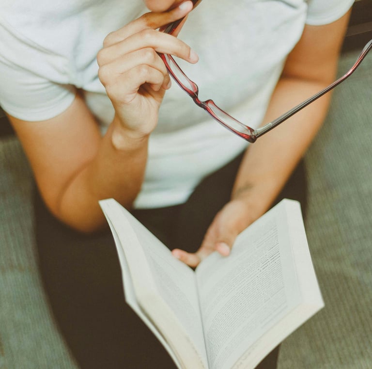 a man in glasses and a white shirt is holding a book