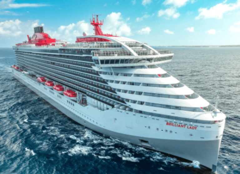 The Virgin Voyages Brilliant Lady cruise ship sailing on the blue ocean under a sunny sky.