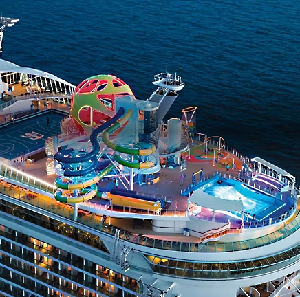 Aerial view of a Royal Caribbean cruise ship featuring water slides and a surfing simulator at sea.