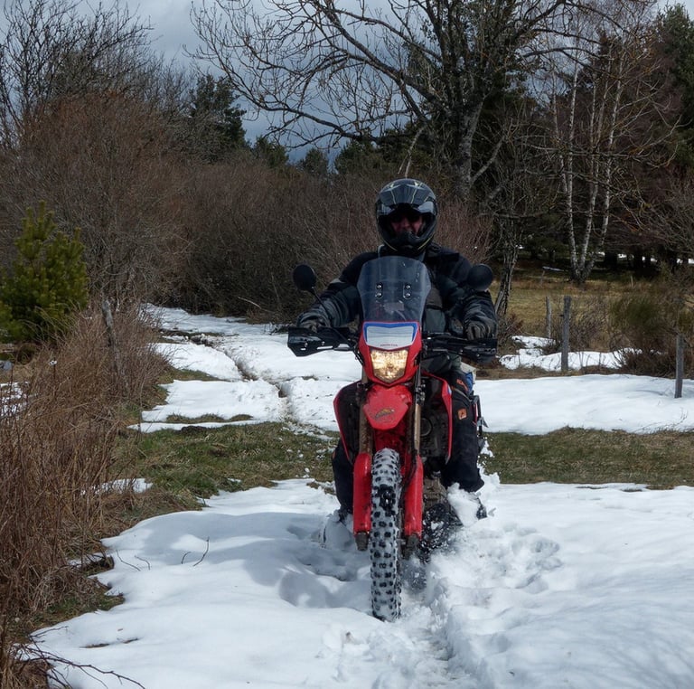 a man riding a motorcycle through the snow