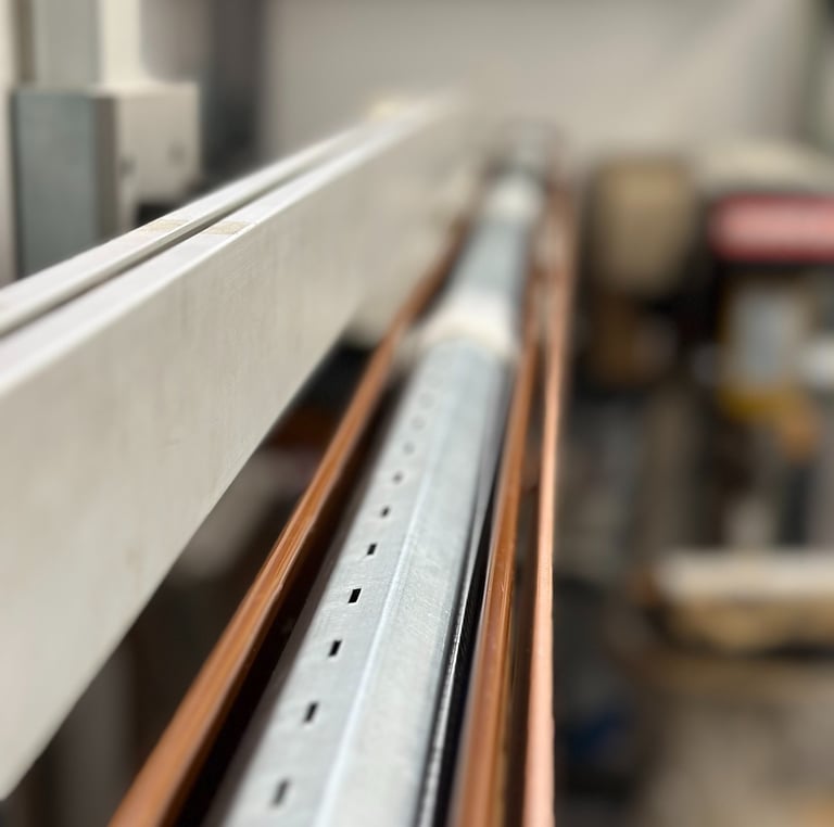 Close-up of an industrial metal roller shutter assembly with galvanized steel and copper components.