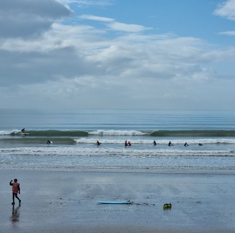 Clean waves breaking at Ynyslas with a surf lesson.
