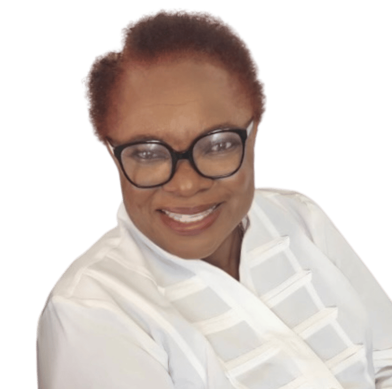 Smiling woman, Mina,  with short auburn hair and black glasses in a professional white blouse.