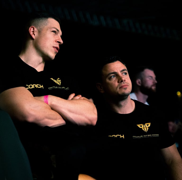 two men sitting on a stage with their arms crossed