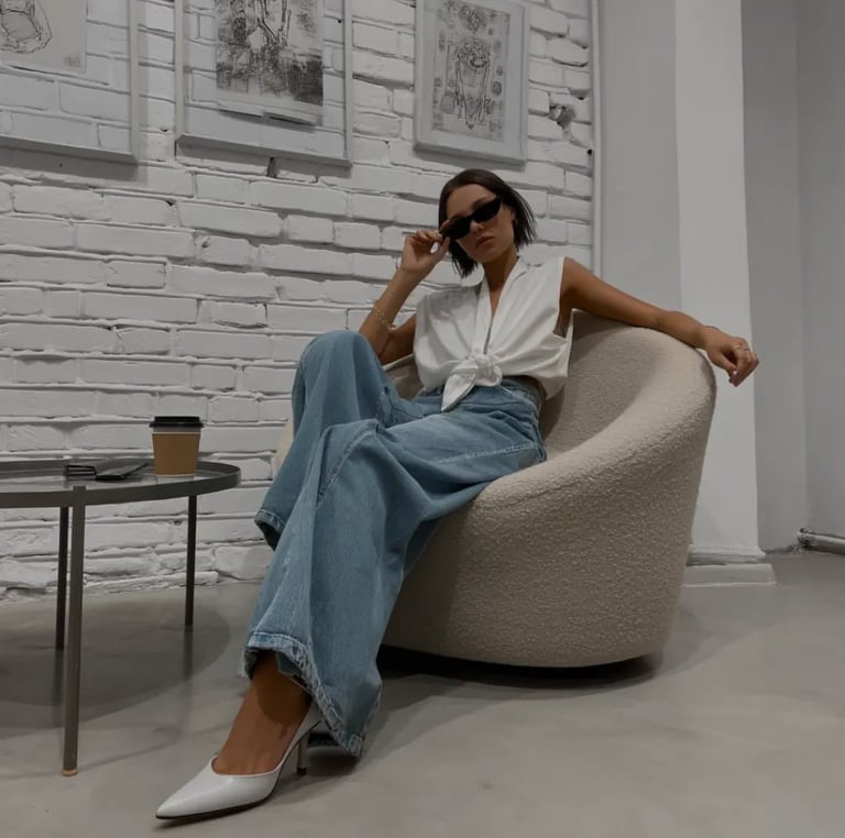 Chica juvenil con outfit moderno sentada en sillón minimalista