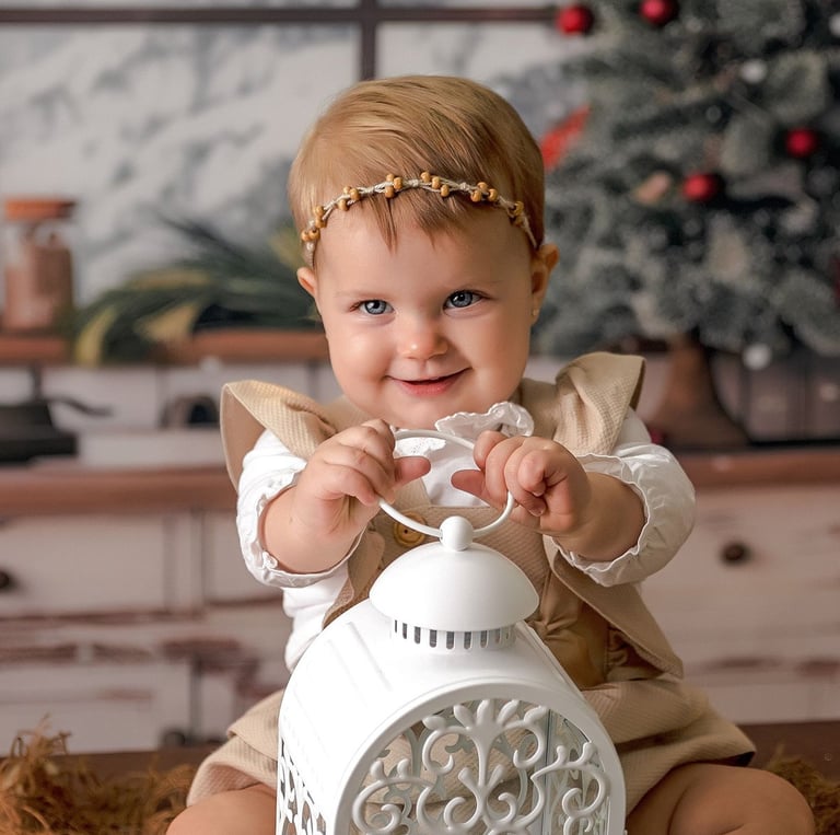 bebé sentada en fondo de navidad con una lámpara