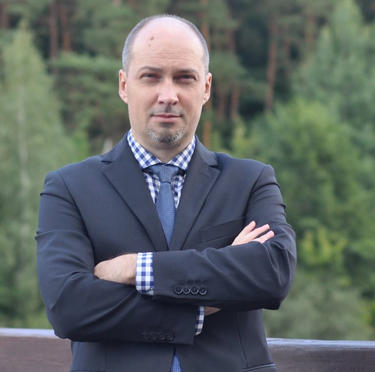 a man in a suit and tie standing on a bridge