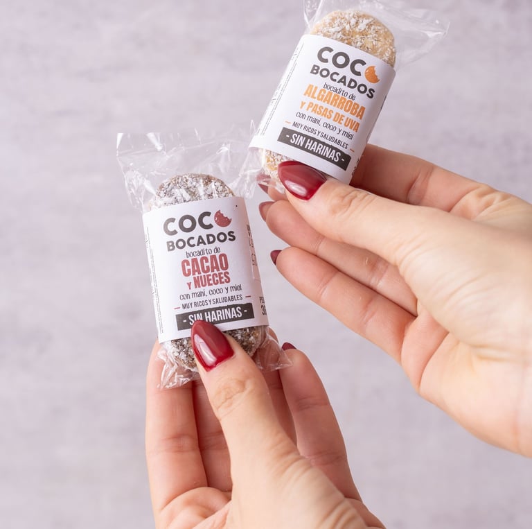 two hands holding two packages of cocoa beans
