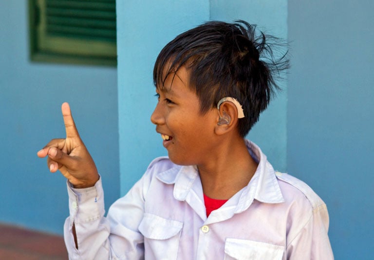a young boy with hearing aid on his head