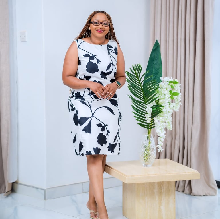 a woman in a white dress standing in front of a table with a vase with