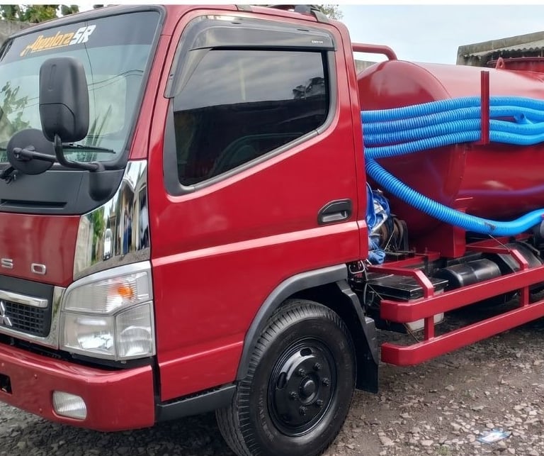 Armada truk Mitsubishi Fuso jasa sedot WC Pekanbaru dengan peralatan selang biru lengkap