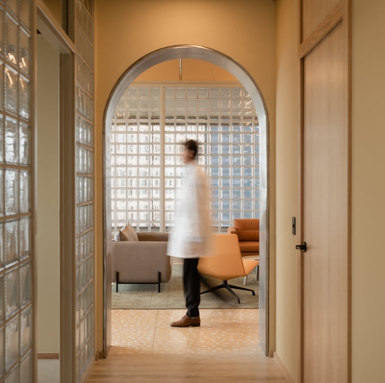 Fertility doctor walking through warm, modern clinic hallway – book a free consultation.