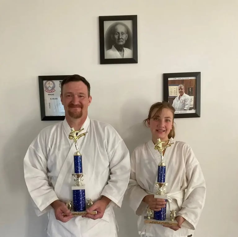 Father and daughter family karate students pose with awards
