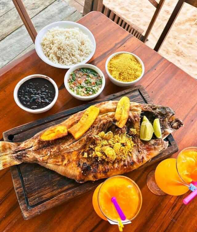 a fish - eating fish on a wooden table, Alter do Chão, Pará, Brazi
