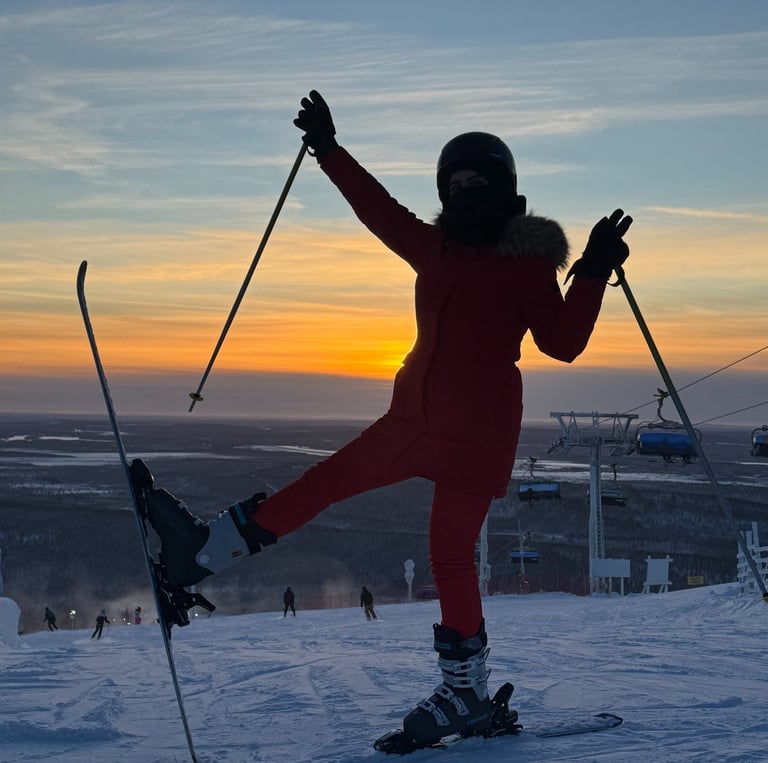a person standing on a ski slope with their arms up