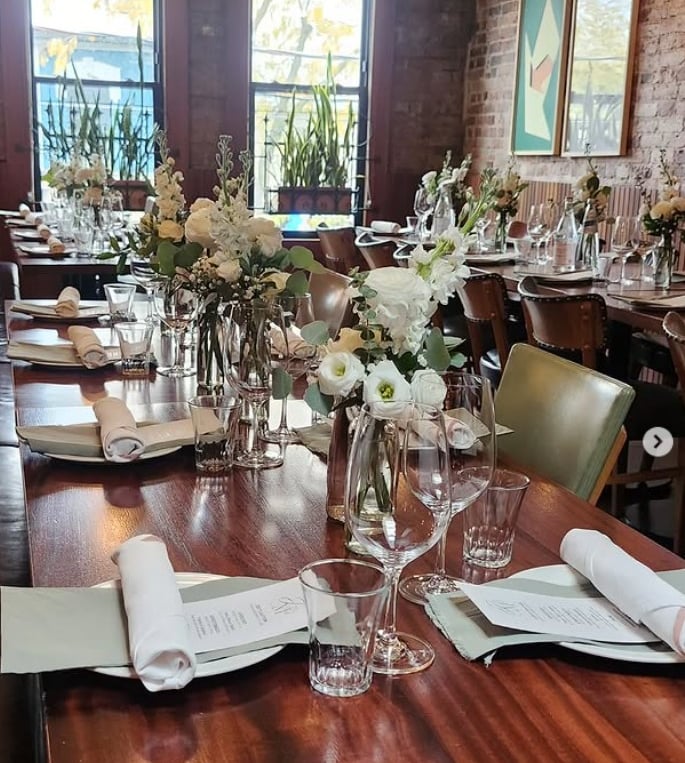 Elegant table setting rentals in Toronto featuring white floral centrepieces, glassware, candles, an