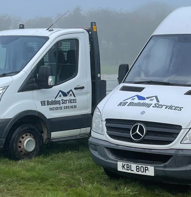 a couple of KB Building Services vans parked in a field