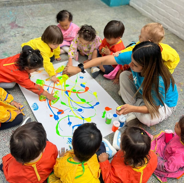 Niños con pinturas brillantes jugando sentados en el piso