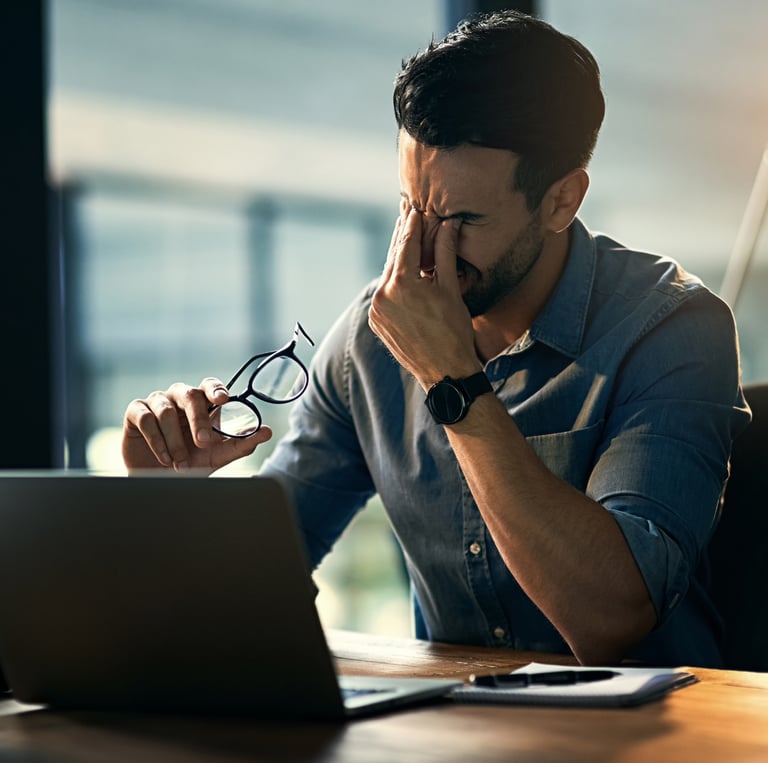 Ein Mann im Büro der zu viel Stress spürt