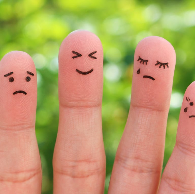 caras feliz, neutra y triste que representan el péndulo emocional y la variación en los estados de ánimo de una persona