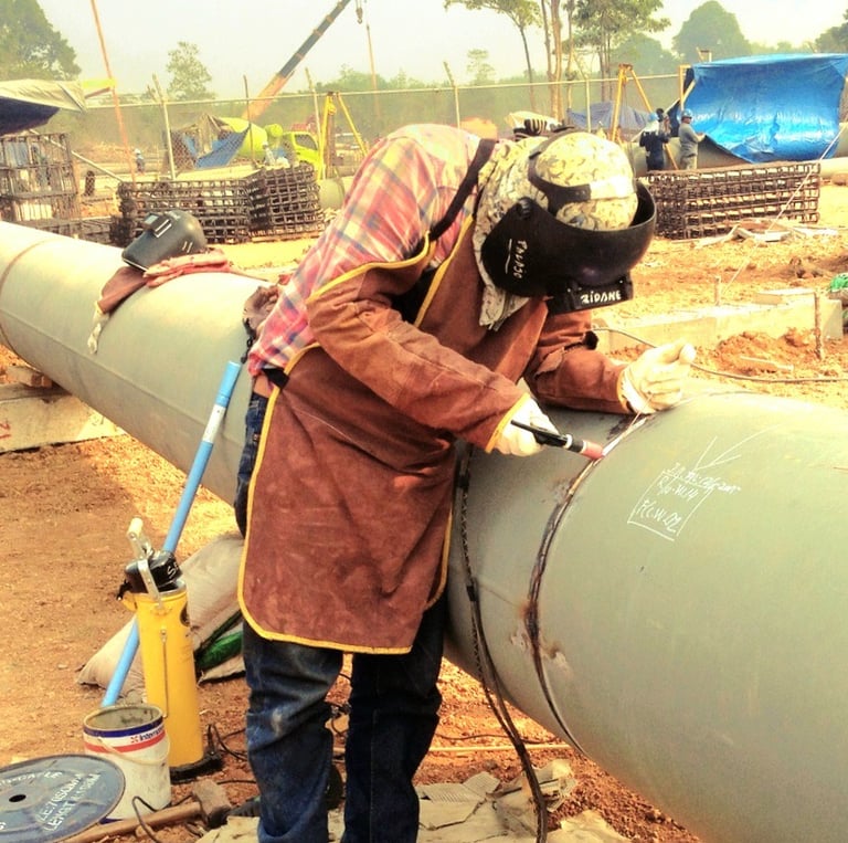 a man in a welding helmet welding a pipe