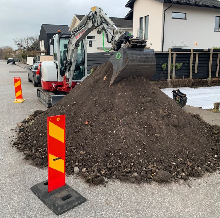 a pile of dirt with a construction worker in the background