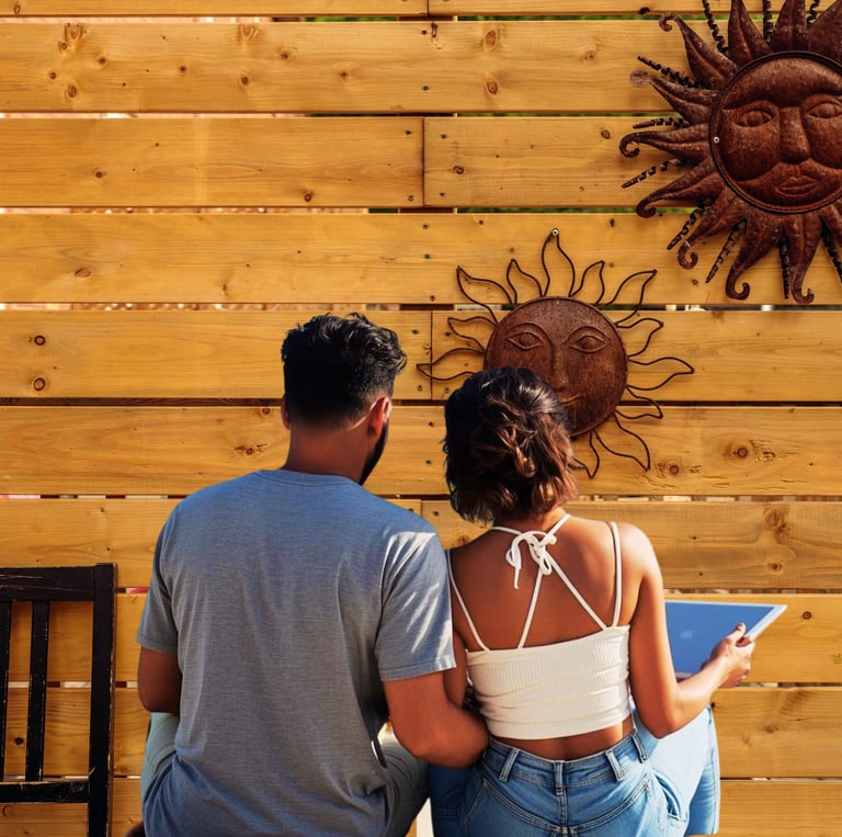Couple sitting outdoors on a wooden deck using a tablet and enjoying some quality time.