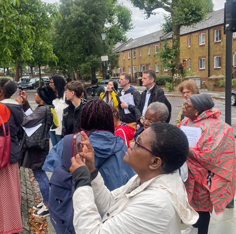 a group of people standing at the site of Kelso Cochrane's housr.