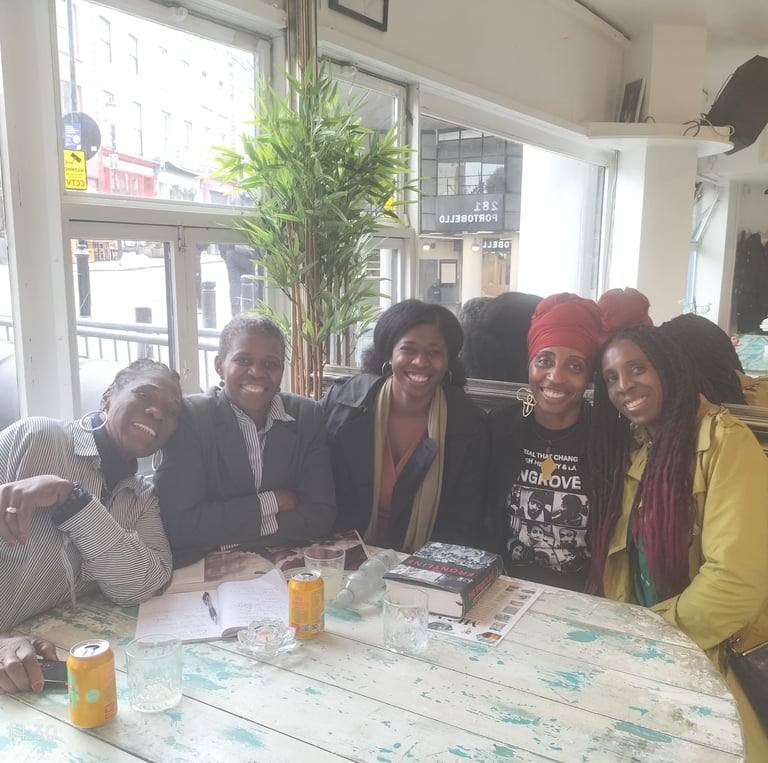 a group of people sitting at a table with drinks discussing Mangrove Nine