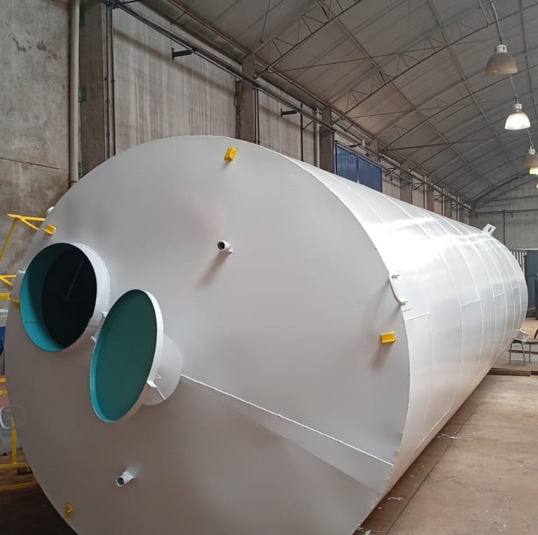 “Reservatório metálico cilíndrico instalado em ambiente industrial, fabricado sob medida+-