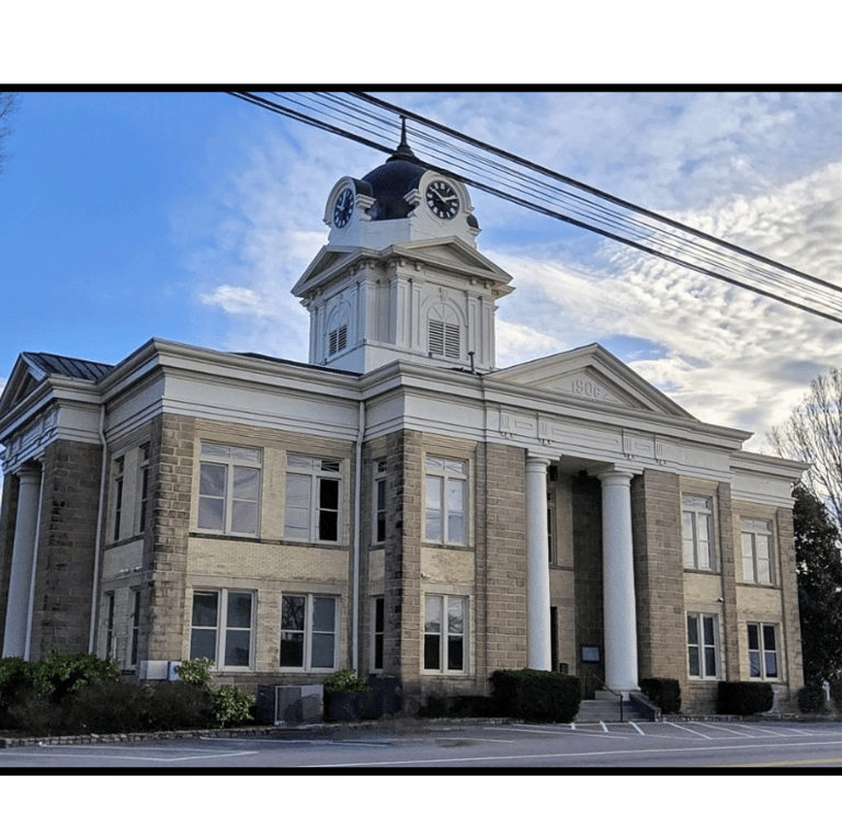 The Franklin County Courthouse in Carnesville, GA with clounds in the sky behind the building.