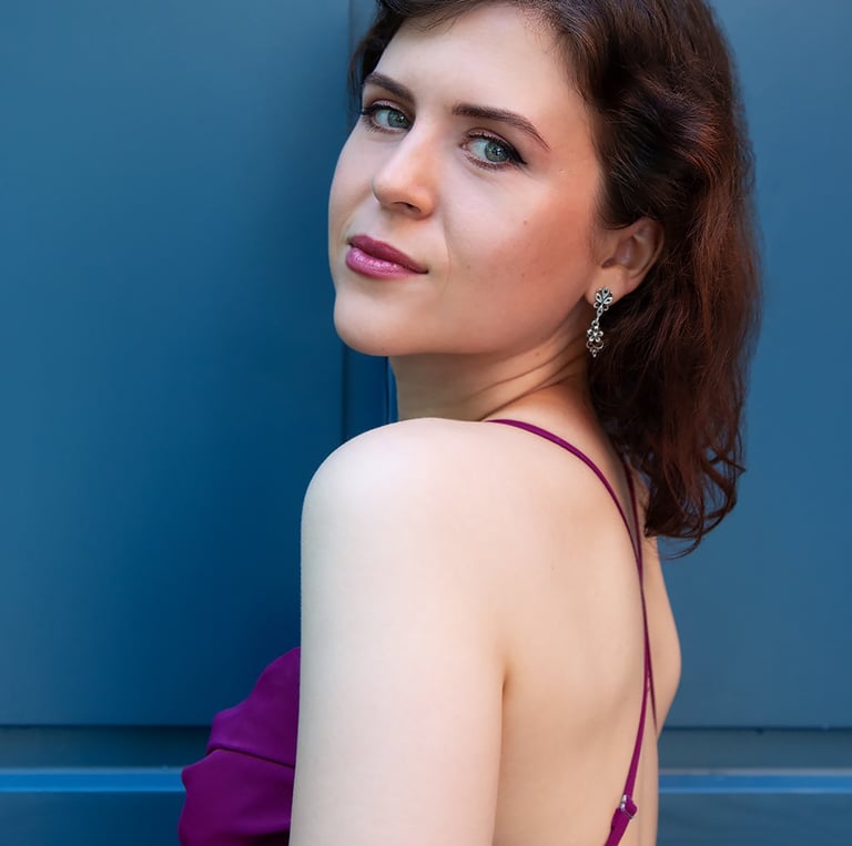 a woman in a purple dress standing in front of a blue door